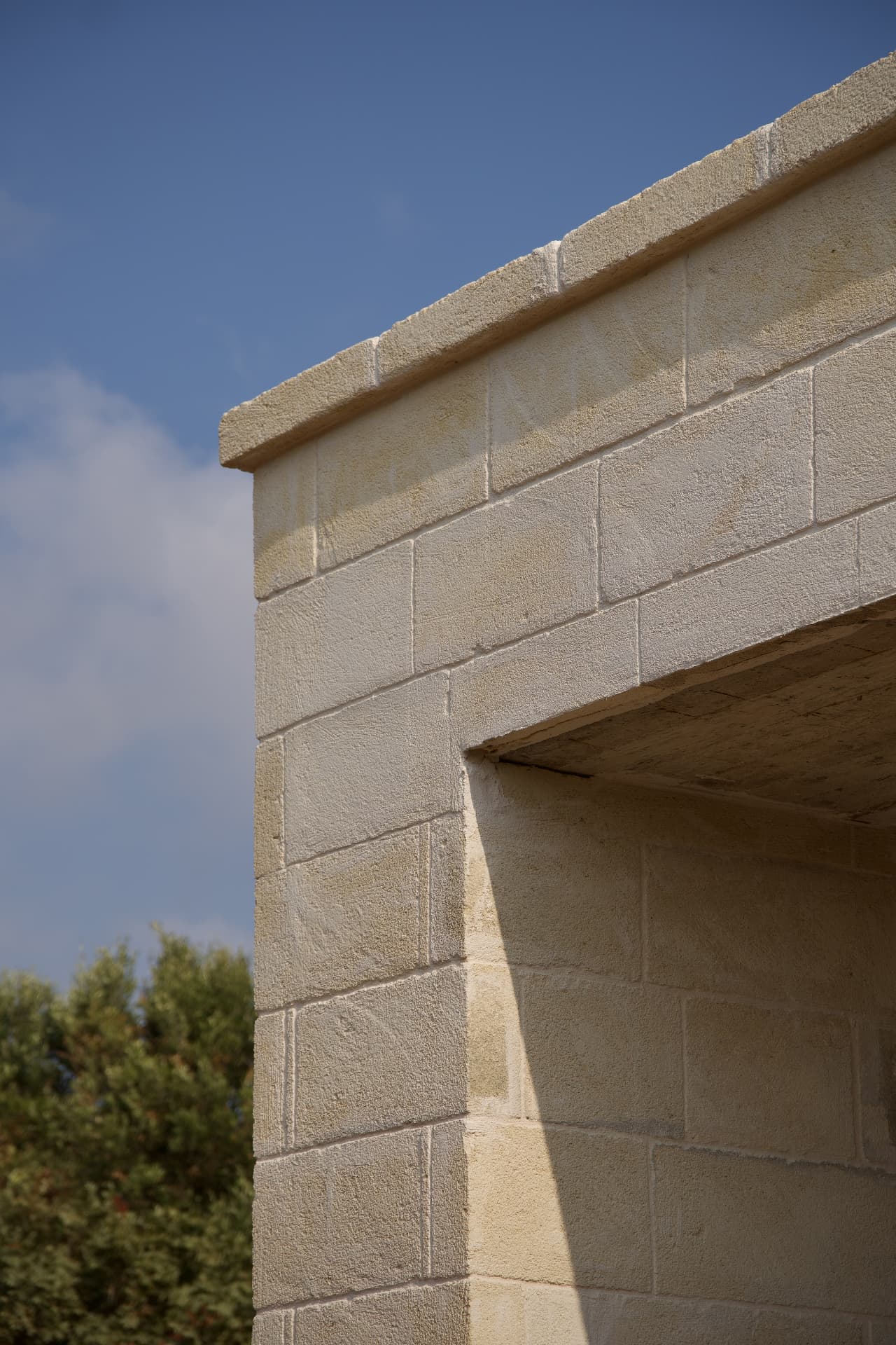 A clean-lined stone corner of a newly built Puglian villa under a bright sky
