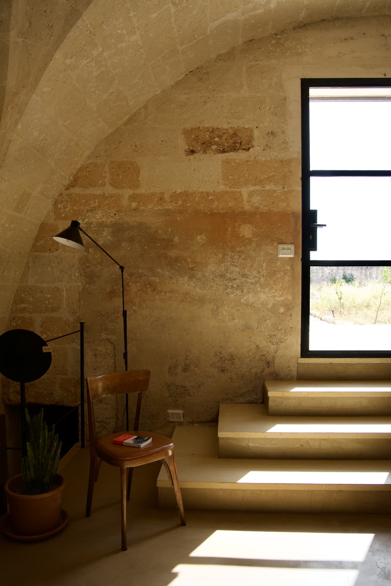 A vaulted stone interior with warm light and simple furnishings in a restored Puglian farmhouse